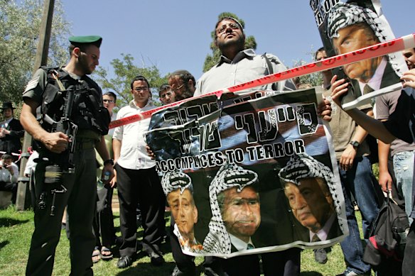 Ben-Gvir (centro) lidera uma manifestação em 2008 ao lado de outros activistas de extrema-direita no local onde um condutor palestiniano colidiu com o seu veículo de construção contra um autocarro e três carros em Jerusalém.