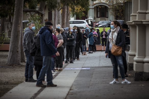 Lines snake around the Royal Exhibition Building in Carlton as people wait for their COVID-19 vaccinations. 