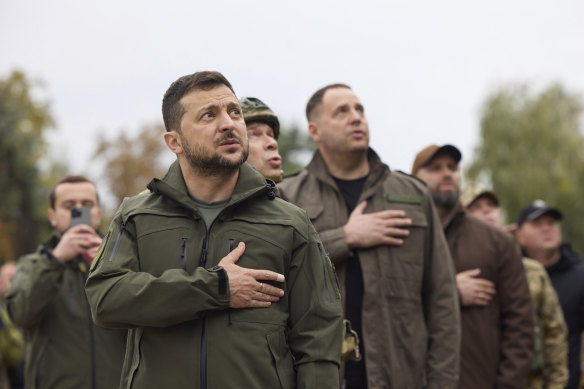 Ukrainian President Volodymyr Zelensky sings the national anthem and raises the Ukraine flag during a visit to the key recaptured town of Izyum.