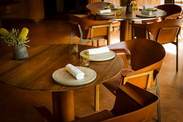 As cadeiras pretas de madeira da Tasmânia, latão e couro moldado em Yiaga, projetadas por John Goulder.