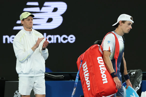 Alex de Minaur leaves the court after losing to Jannik Sinner (right).