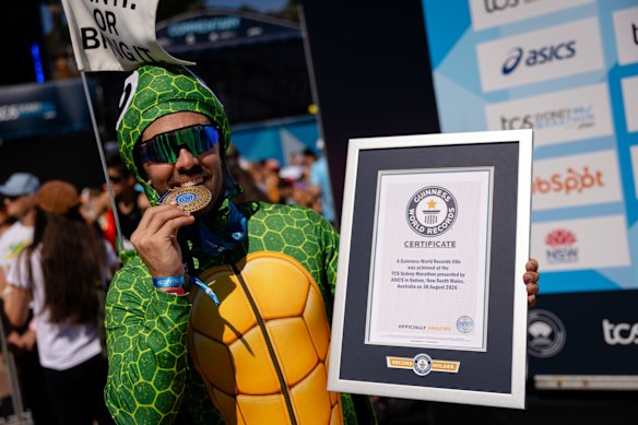 Phil Brent poses with his Sydney Marathon medal and his new world record. 