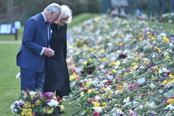 Prince Charles and Camilla, the Duchess of Cornwall, inspect flowers left for Prince Philip. 