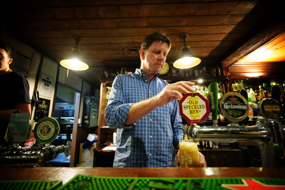 Gary Kirwan, owner of the Sherlock Holmes Inn, pours a pint of English beer to prepare for an influx of patrons. 
