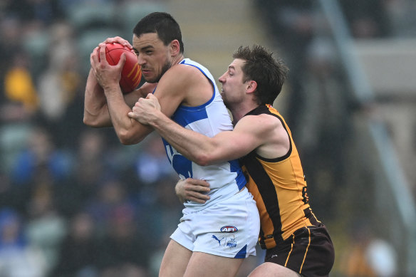Luke Davis-Uniak of the Kangaroos is intercepted by Dylan Moore of the Eagles.
