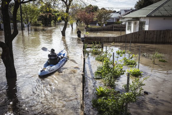 A person paddles through a street in Maribyrnong.