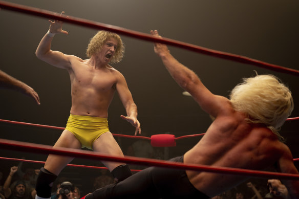 Harris Dickinson as Mike Von Erich unleashes the iron claw move on his opponent Ric Flair in The Iron Claw. 