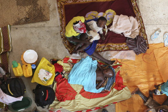 A mother and her children prepare for the night inside a Roman Catholic Church in Pemba city on the northeastern coast of Mozambique. Extremist rebels decapitated those they captured when they attacked the town. 