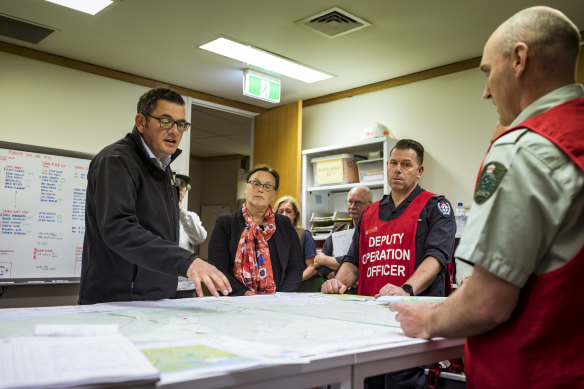 Premier Daniel Andrews is briefed by emergency services personnel in Orbost