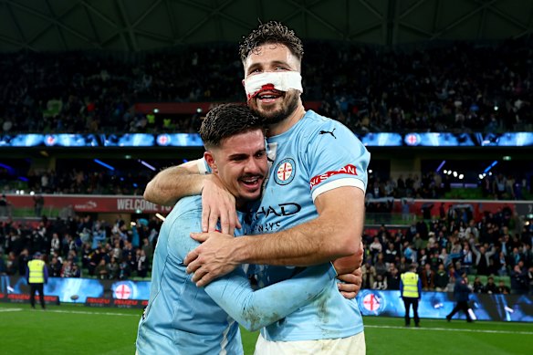 Melbourne City’s Marco Tilio and Mathew Leckie embrace after winning the A-League grand final.