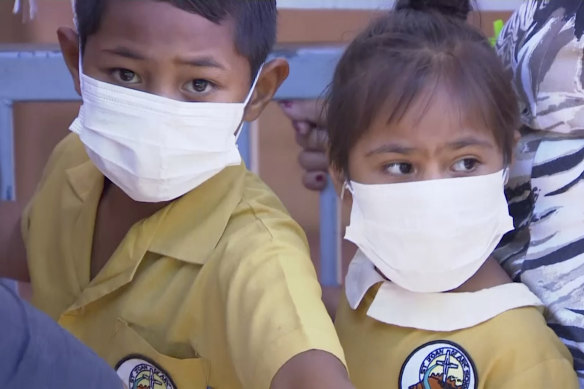 Masked children wait to get vaccinated at a health clinic in Apia, Samoa. Samoa has closed all its schools and banned children from public gatherings due to a measles outbreak. 