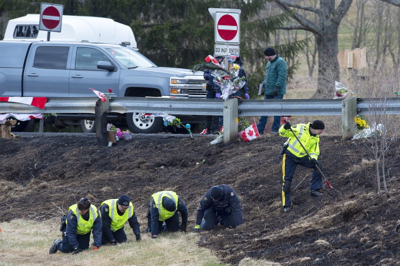 Royal Canadian Mounted Police investigators search for evidence at one of the shooting scenes.