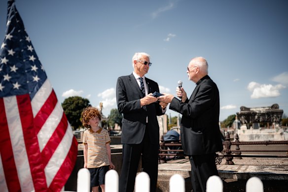 Melbourne Anglican priest Roger Featherson (right) presents Harry Lane’s New Testament to Lane’s great-grandson Roger Blake-Lane (centre) at Lane’s grave.