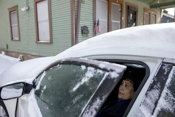 Maria Pineda warms up in her car outside her home in East Austin, Texas, during a power outage caused by the snow storm last week.