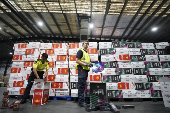 Australian Border Force officers checking illegal cigarette imports found in shipping containers in Melbourne.