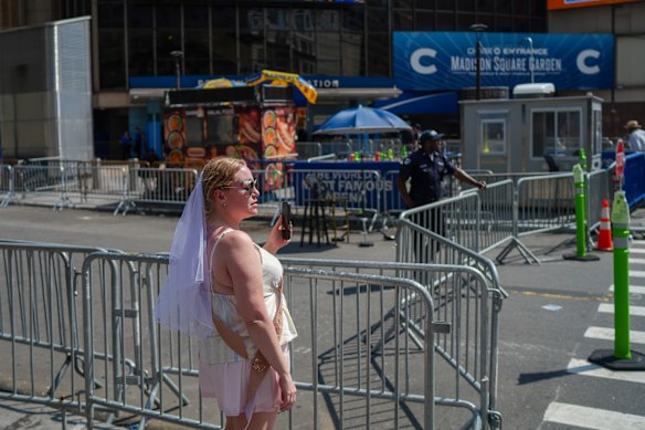 A woman wearing a bridal veil stands outside Madison Square Garden ahead of the wedding between singer Taylor Swift and National Football League player Travis Kelce on Friday, July 3, 2026, in New York. (AP Photo/Ryan Murphy)