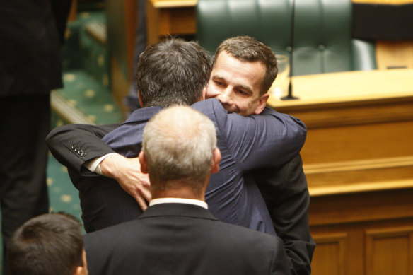 Euthanasia bill sponsor David Seymour, rear right, embraces other MPs in parliament in Wellington after passage of the bills in 2019.
