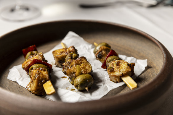 Octopus skewers with ’nduja, green olives and red peppers.