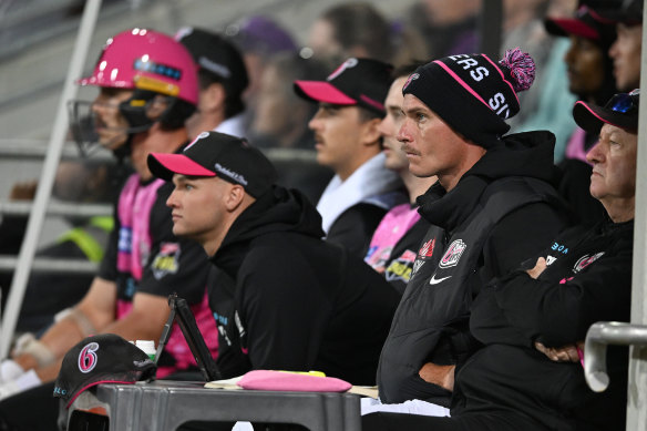 Sixers players look on in the dugout.