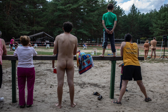 Campgoers watch the finish line of a nude triathlon Zossen, Germany.