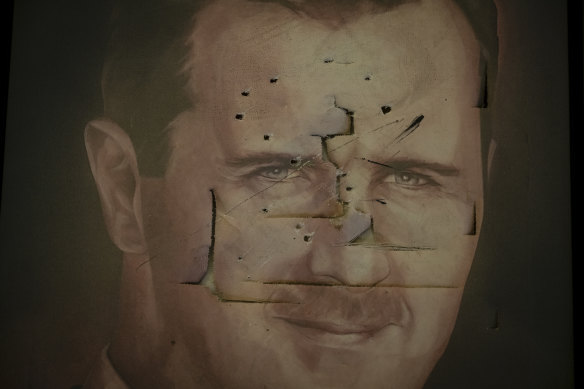 A defaced portrait of Bashar al-Assad inside the presidential palace.