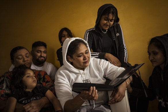 Jasmin Hussein weeps as she and her family (Eiliya, Grandma Rita, Zaahir, Imani, Aleena and Ammara) look through a photo album containing photographs of her deceased 14-year-old daughter Alisha.