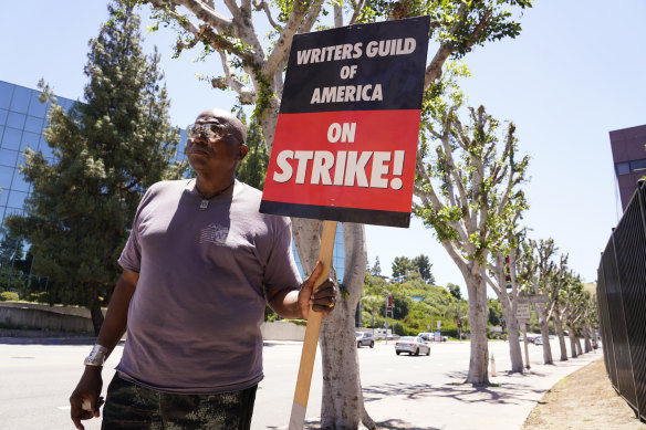 WGA and SAG-AFTRA member Dee Thompson walks past trees on a picket line outside Universal Studios on Wednesday in Burbank, California.