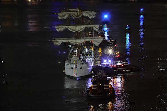 Tugs assist the stricken ship.