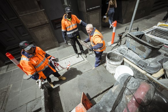 Workers laying bluestone pavers in Melbourne’s CBD.