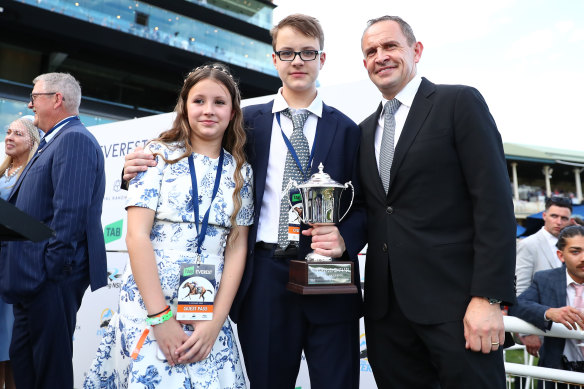 Winning trainer Chris Waller’s children,  Nikita and Tyler, join their father on stage for the presentation.