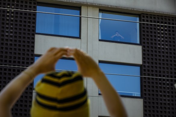 A Bangladeshi refugee signals 'joy' to protestors outside a Carlton hotel.