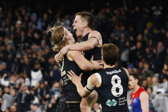 Tom de Koning lifts Carlton teammate Matthew Owies after a goal against Melbourne.
