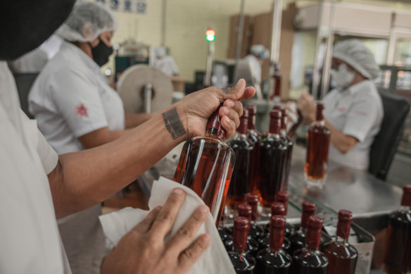 Jose Colbi, a rehabilitated gang member, seals bottles at the Santa Teresa rum factory in Sabaneta, Venezuela. 