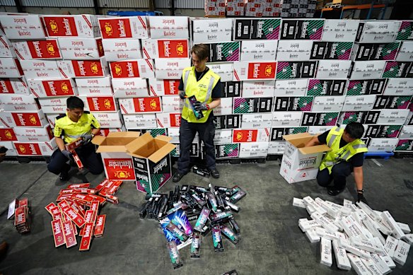 Australian Border Force officers check illegal cigarette imports found in shipping containers.
