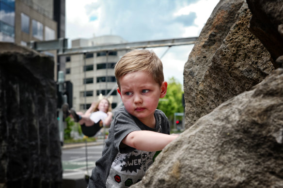 Three-year-old Ryder takes on a boulder at the new Southbank playground.