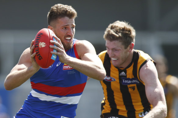 Marcus Bontempelli of the Bulldogs is tackled by Hawthorn’s Ben McEvoy.