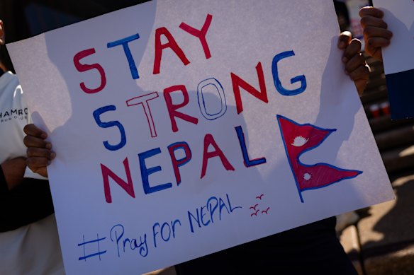 A race supporter holds up a sign for Nepal. 