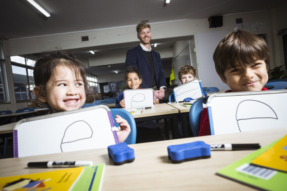 Port Melbourne Primary School prep students Brooklyn, Chloe, Felix and Gonzalo use an explicit instruction approach to learning to read with principal Tom Cain. 