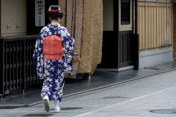 A Maiko, or apprentice Geisha, walks along the famous Gion district’s Hanamikoji Street lined with teahouses. 