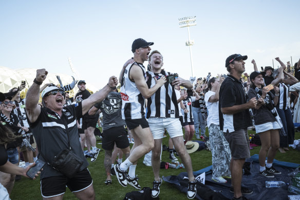 Fans celebrate Magpies winning the grand final at the Collingwood fan site at Olympic Park.