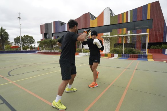 Sam Sokhom and Elvis Sundara practise boxing outside the Springvale Hub.