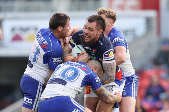 David Klemmer is tackled by three Bulldogs.
