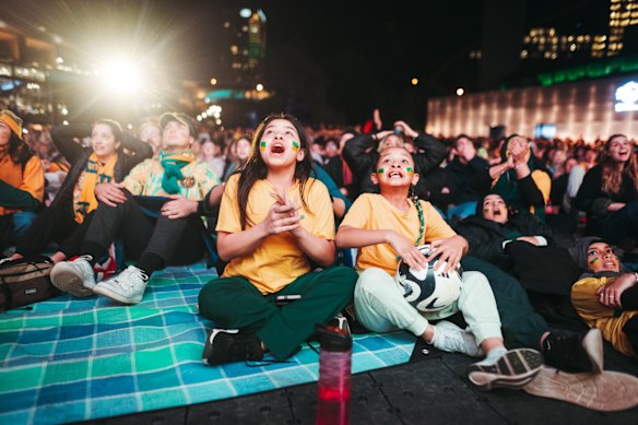 Fans react to the growing tension of the of the match, at Darling Harbour in Tumbalong Park.