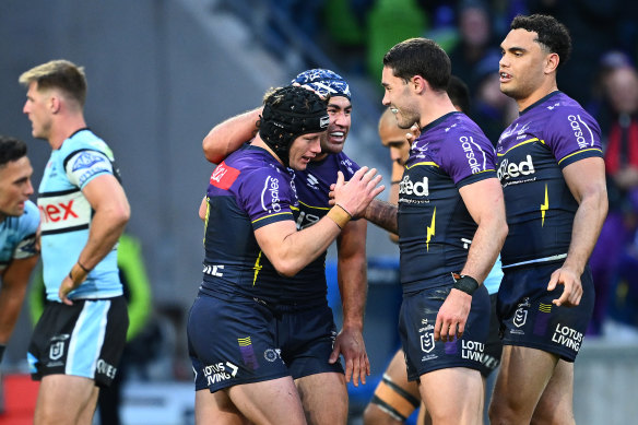 Harry Grant of the Storm, black helmet, celebrates with Jahrome Hughes and other teammates after scoring a try.
