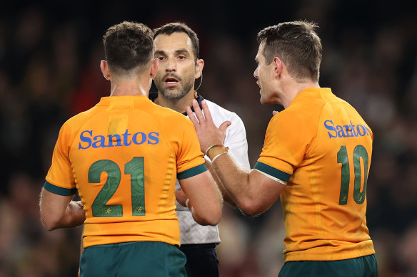 Referee Mathieu Raynal explains his 79th-minute decision to Nic White and Bernard Foley.