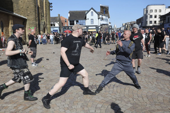 A fight breaks out between anti-fascists, left, and other people protesting in Blackpool, England.