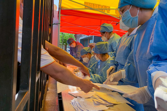 Medical workers sort coronavirus test results in Beijing on Sunday.