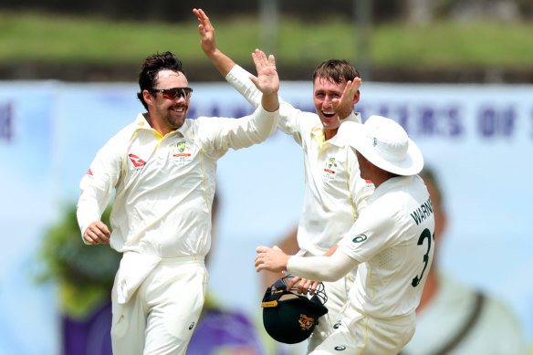 Travis Head celebrates with teammates after snaring a rare Test wicket.