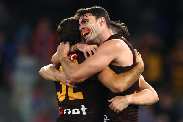Hawthorn players celebrate their upset win over the Bulldogs, coming from behind twice to snatch a win. 