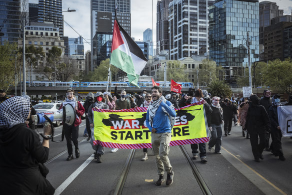 Anti-war protesters walk through Melbourne’s CBD, causing traffic disruption.
